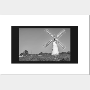 Traditional windmill on the riverbank in rural England Posters and Art